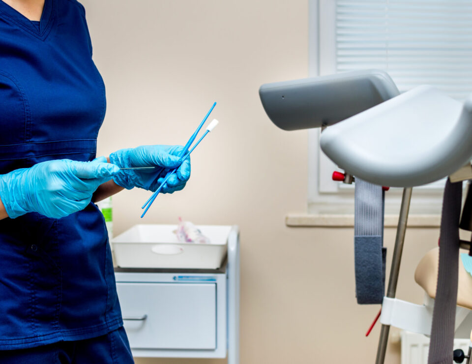 gynecologist holds instruments for taking tests from a woman. Gynecologist's office
