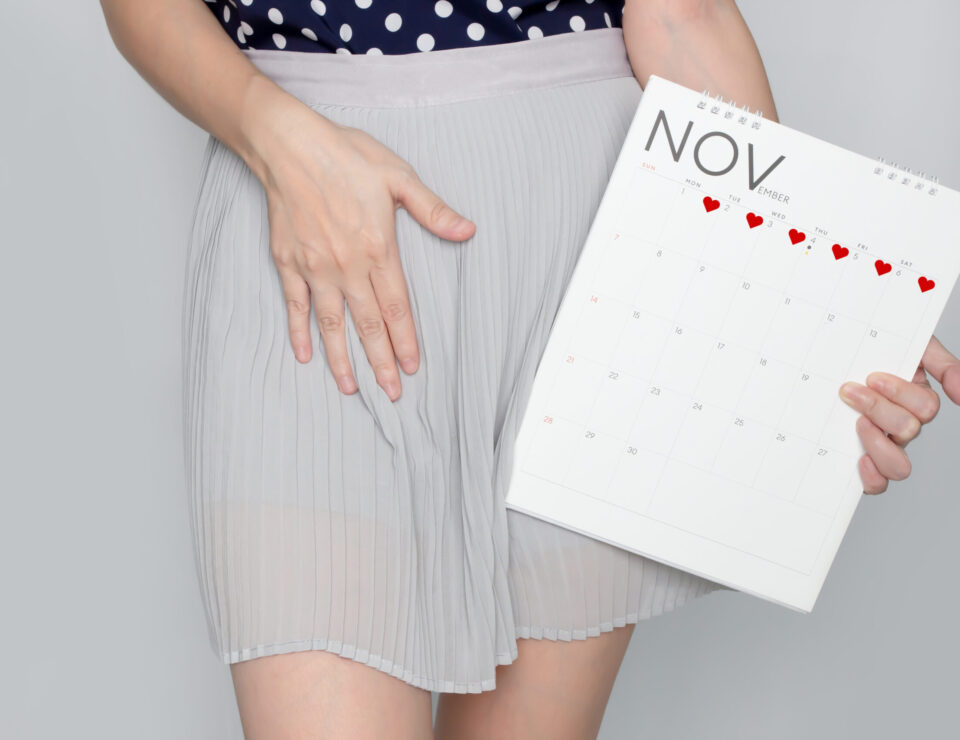 Woman holds calendar, touch stomach, menstruation problem, pregnant. A PMS.